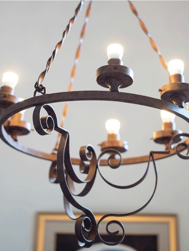 A wrought iron chandelier is hanging from the ceiling