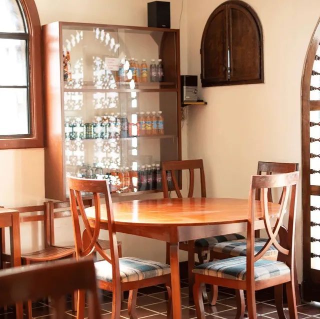 A dining room with a table and chairs and a display case