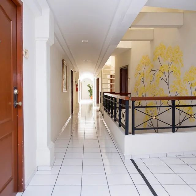 A hallway with a railing and yellow flowers on the wall