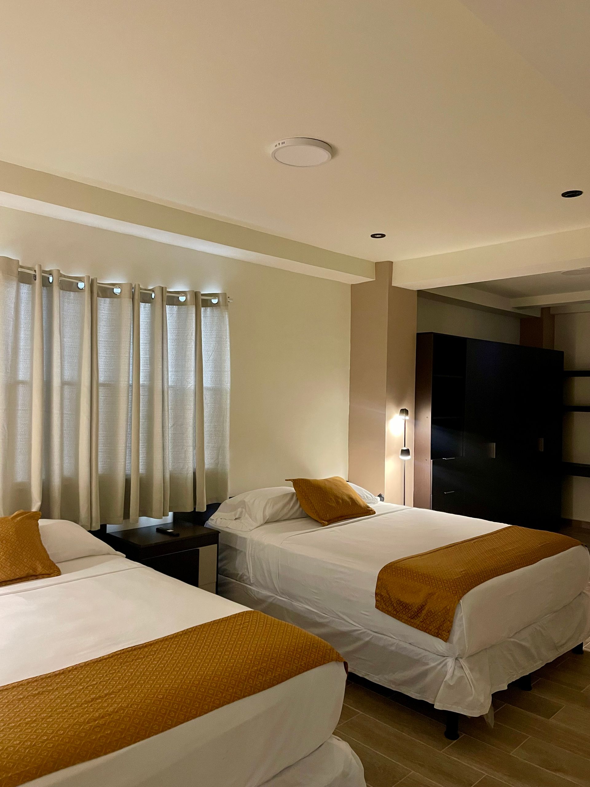 A hotel room with two beds and a window