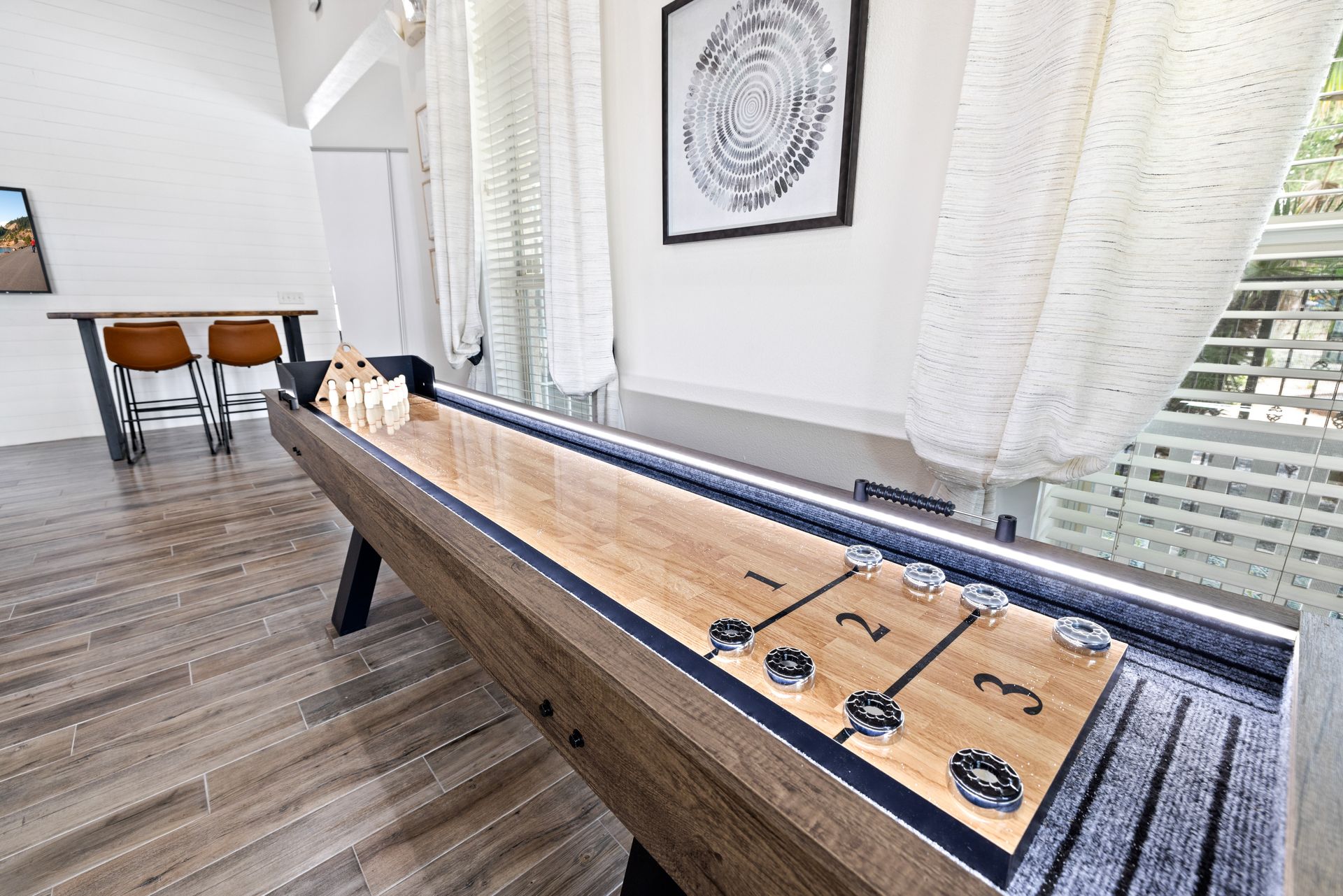 There is a shuffleboard table in the middle of the room.