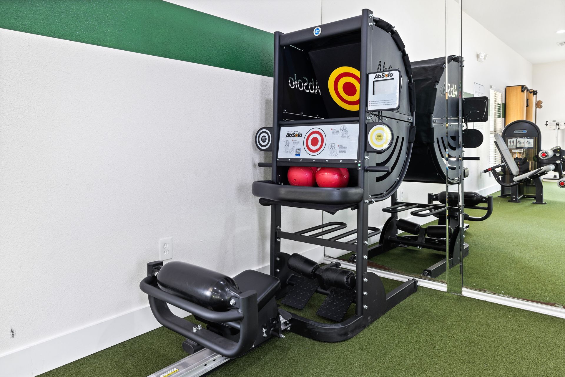 A gym with a machine that looks like an arcade machine.