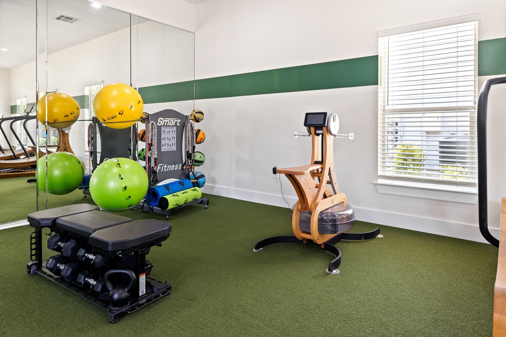 A gym with a lot of exercise equipment and a large mirror.