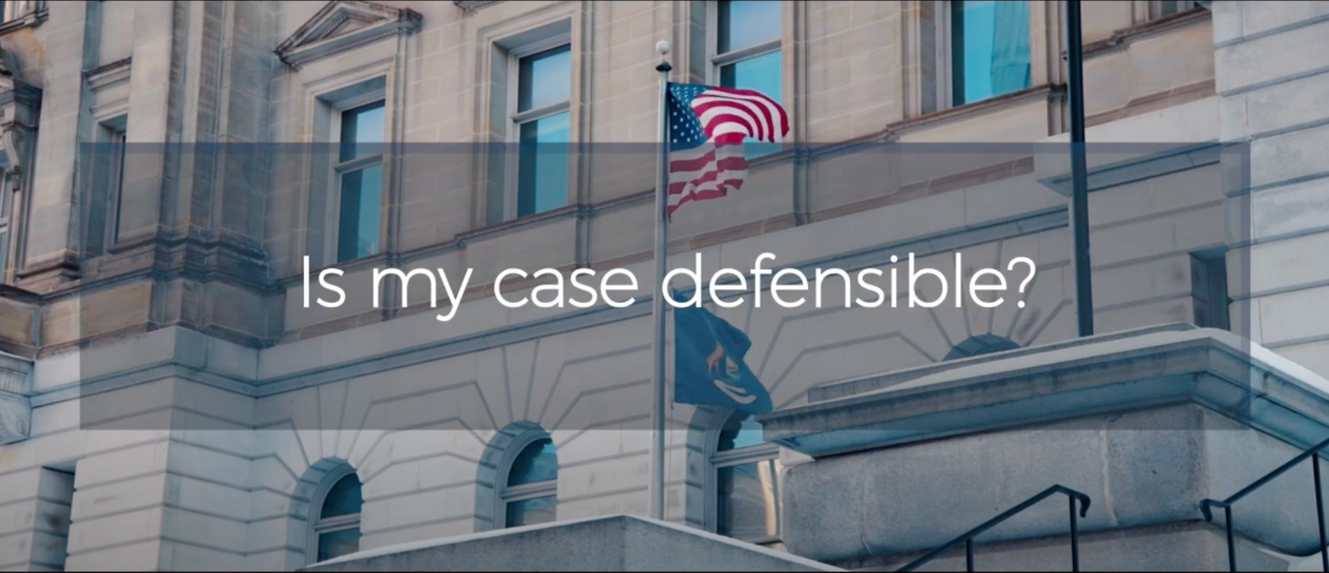 A large building with a flag on top of it and the words `` is my case defensible ''.