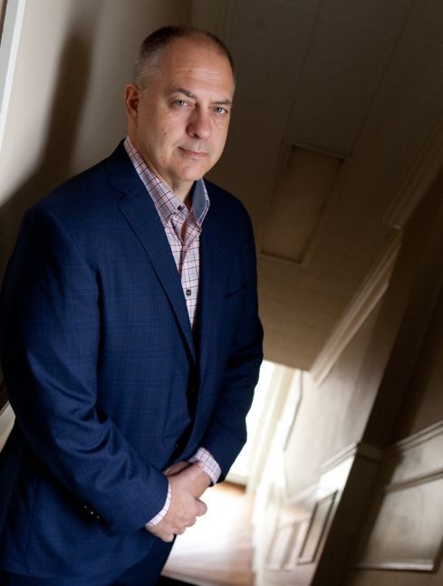 A man in a blue suit is standing on a set of stairs.