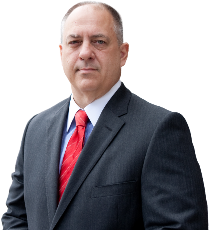 A man in a suit and tie is standing with his hands folded