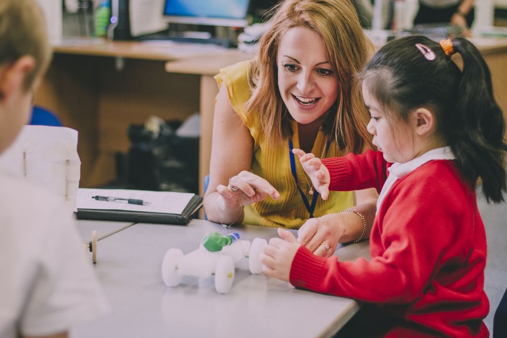 A Teacher Is Playing With A Little Girl In A Classroom — The Therapists Cairns In Cairns City, QLD