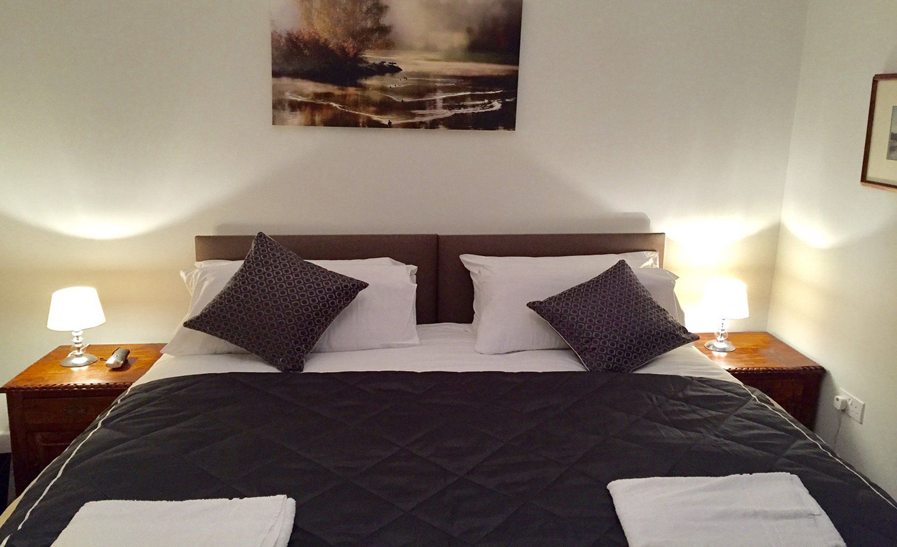 the master bedroom with sumptious bedspread and woodland picture on the wall