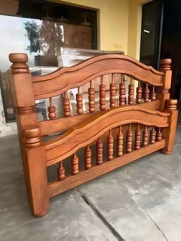 Una cabecera de madera está apoyada en el suelo en una habitación.