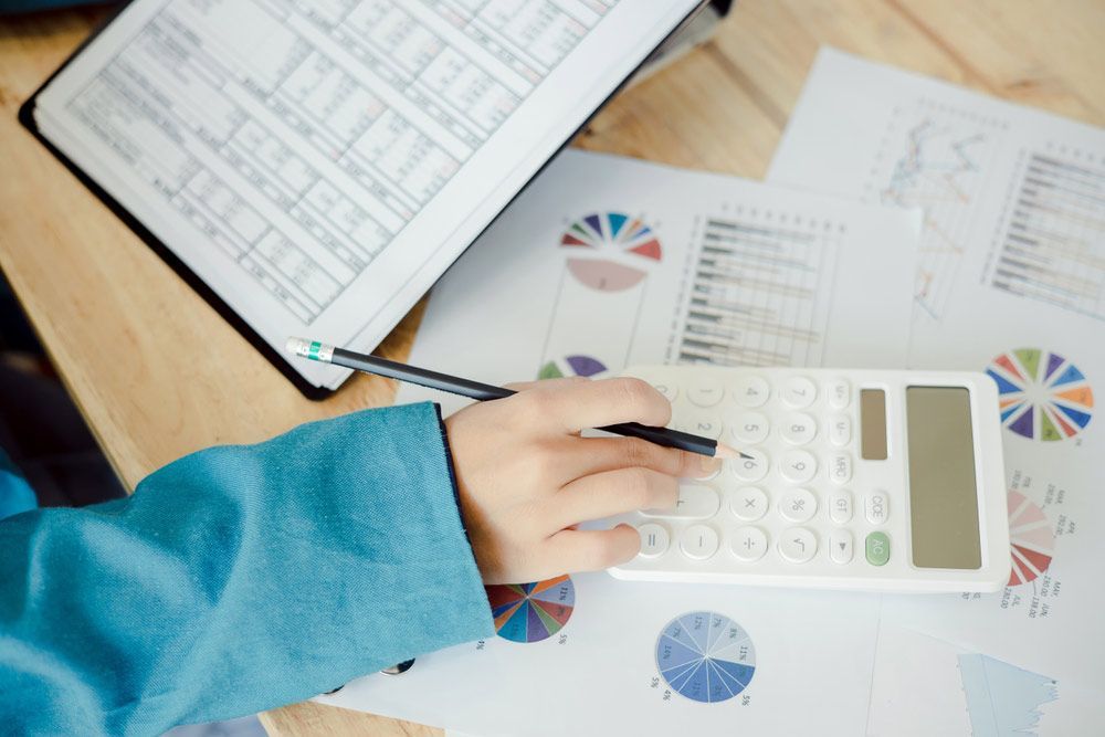 Accountant Woman Using A Calculator To Calculate The Numbers — Dynamic Accounting Taxation Advisors in Gosford, NSW