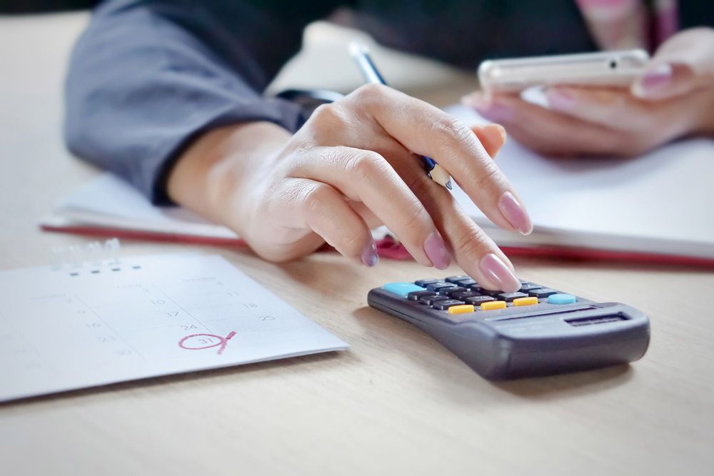 Accountant Hand Calculating Expenses During Tax Season — Dynamic Accounting Taxation Advisors in Erina, NSW