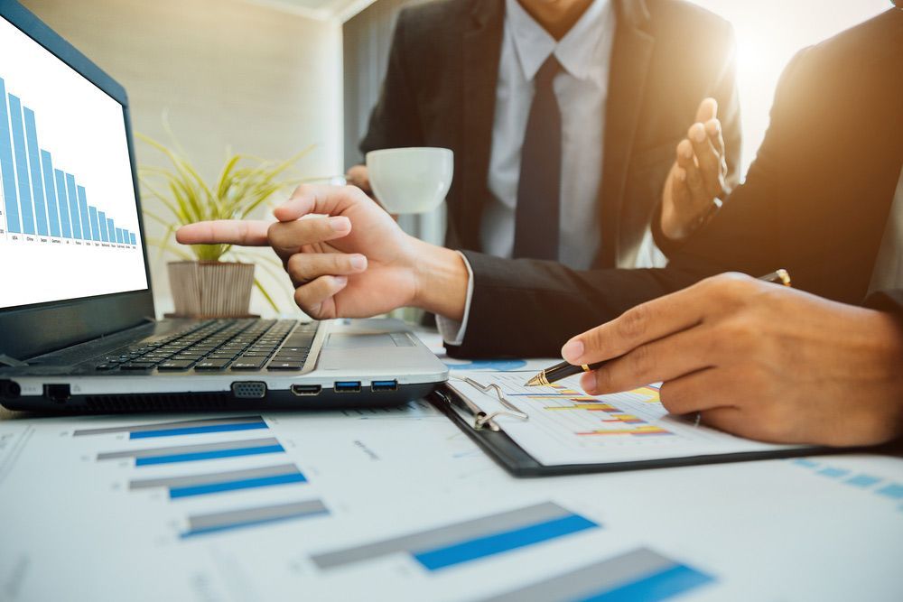 Two Men Making Audit With Laptop And Paper Documents — Dynamic Accounting Taxation Advisors in Terrigal, NSW