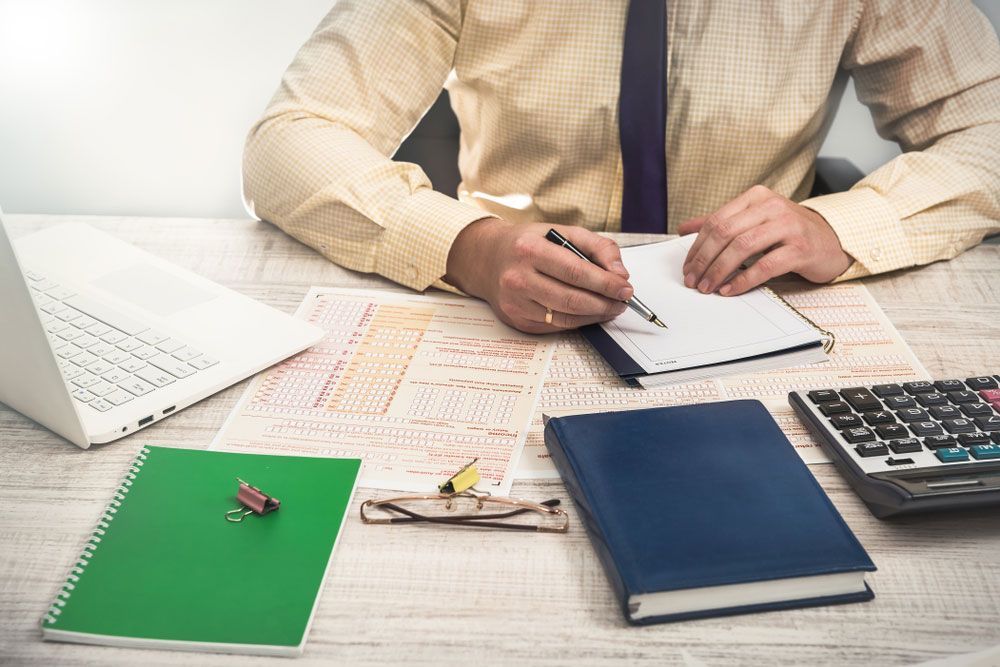 Man Fills In Australian Tax Forms — Dynamic Accounting Taxation Advisors in Kincumber, NSW