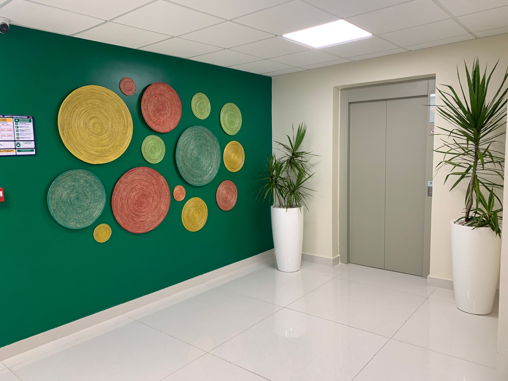Un couloir avec un mur végétal et une plante en pot.