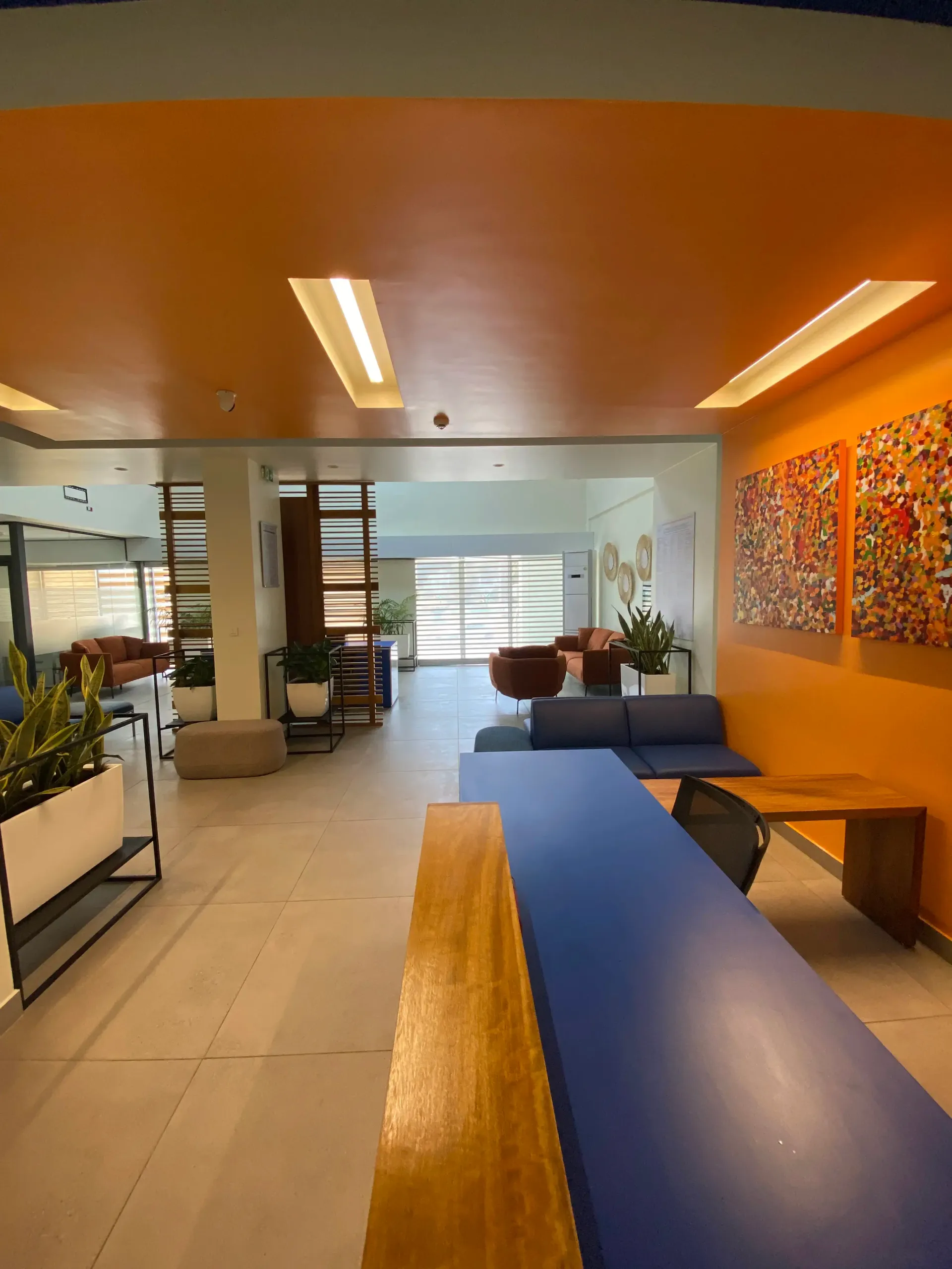 Un salon avec une table bleue et des murs orange
