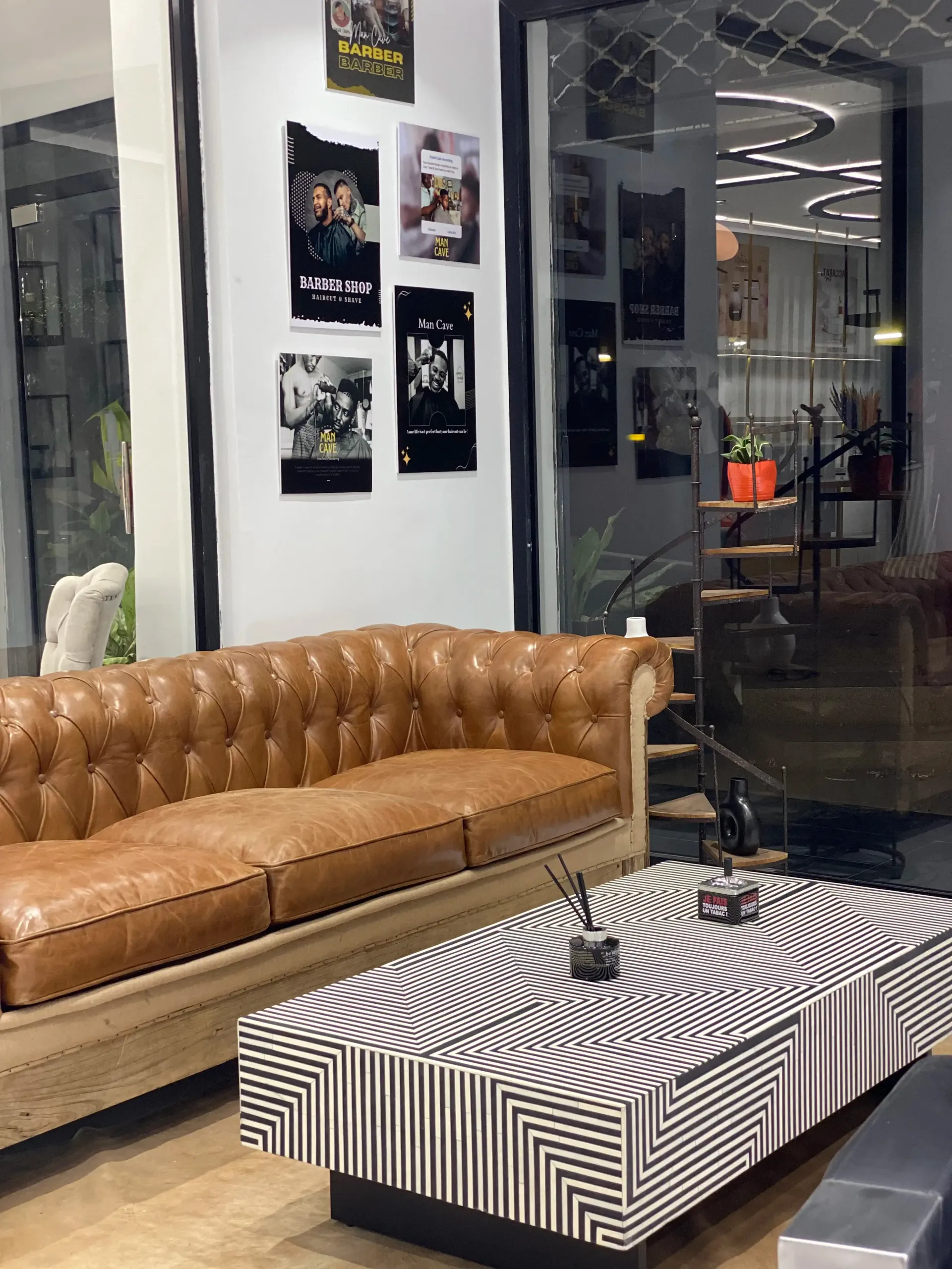 Un salon avec un canapé marron et une table basse noire et blanche.