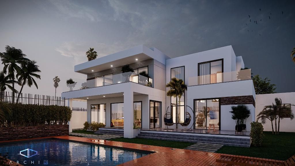 Une grande maison blanche avec une piscine devant.