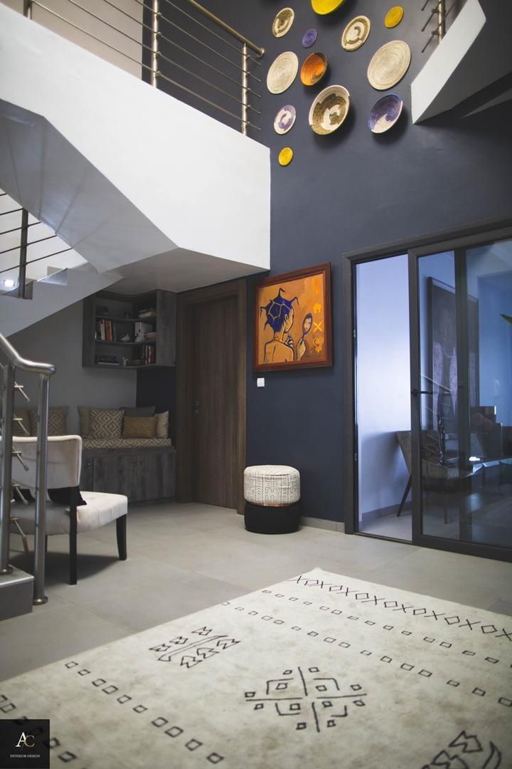 Un salon avec un escalier et un tapis au sol