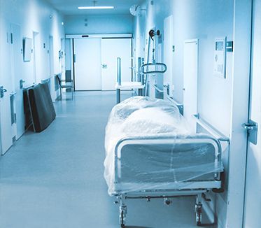 Un couloir d'hôpital avec un lit au milieu.