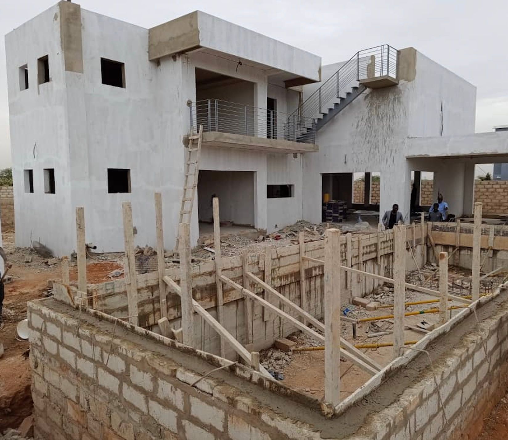 Un grand bâtiment blanc en construction avec des escaliers menant au deuxième étage