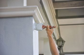 A person is painting a wall with a brush.