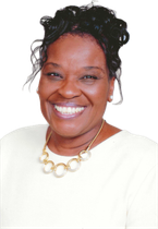 Smiling woman in a white top and gold necklace against a white background
