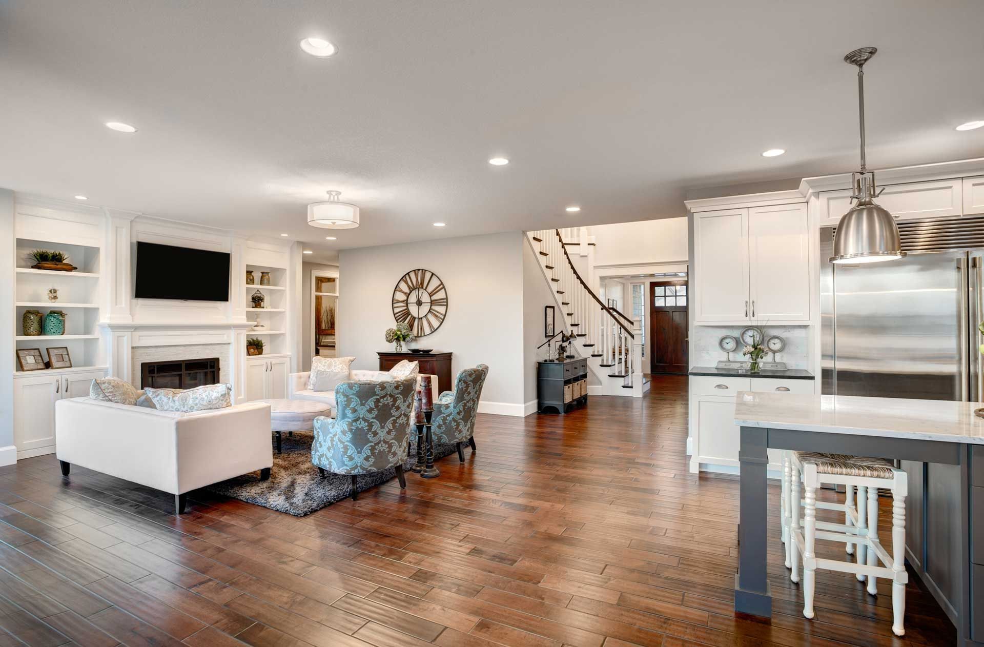 A living room and kitchen in a new home with hardwood floors.