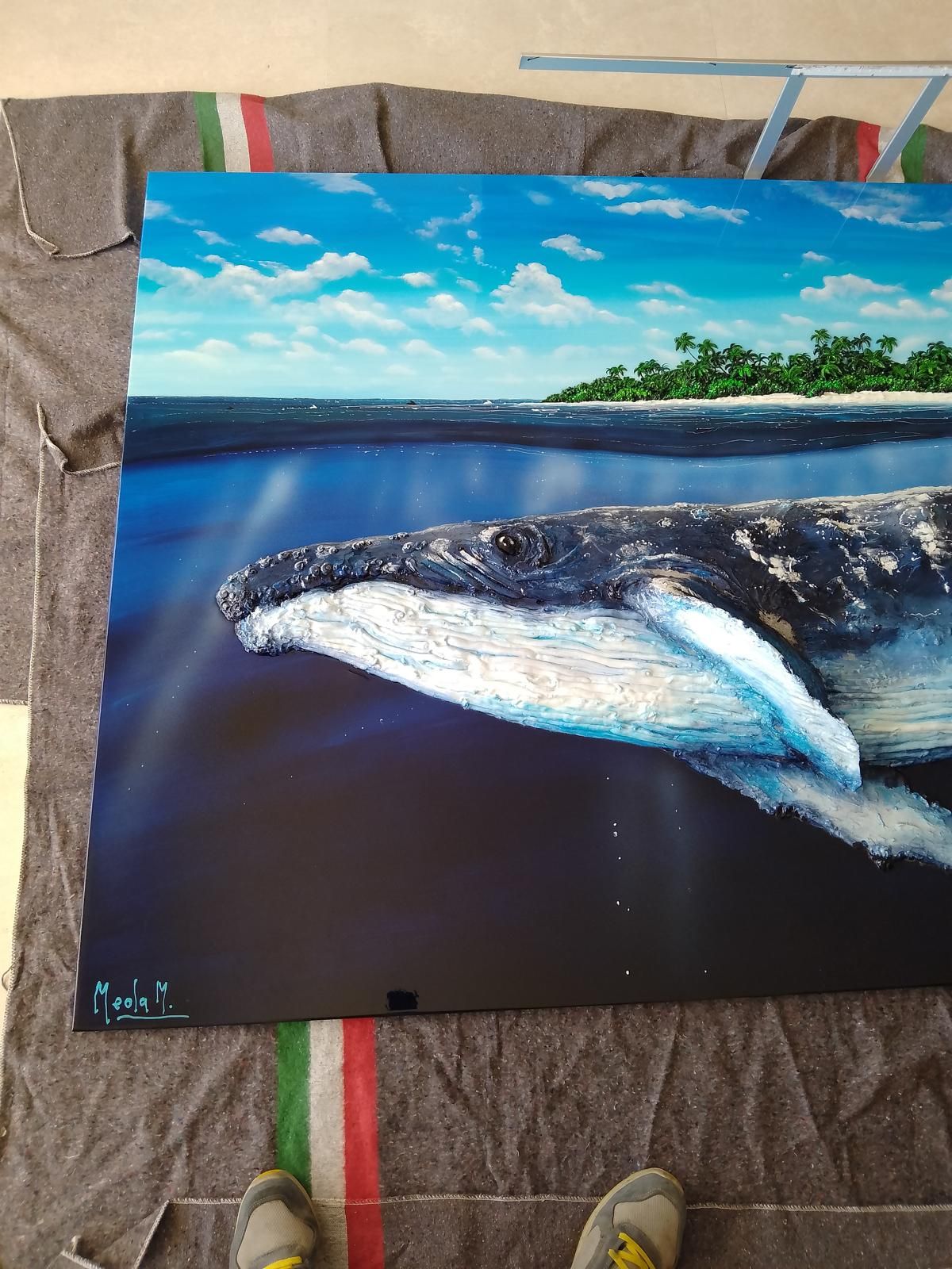 Balena che nuota sott'acqua vicino a un'isola con cielo azzurro, giornata di sole.