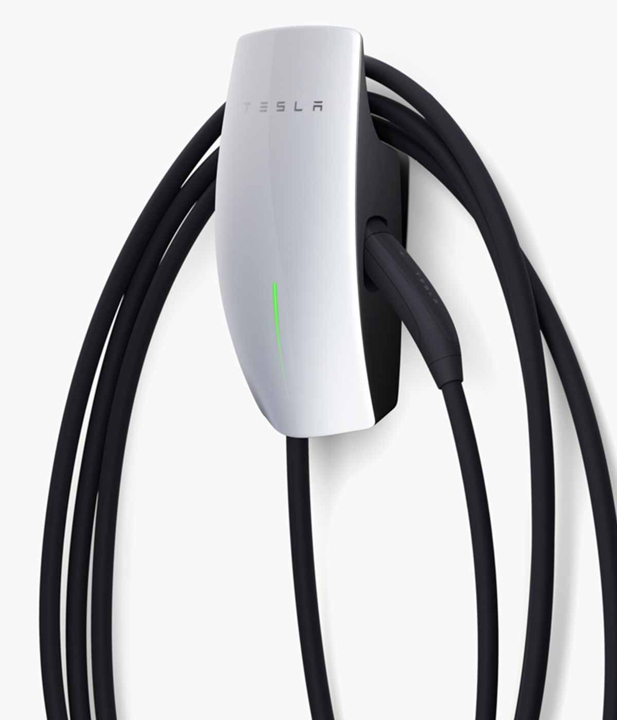 Tesla Wall Connector, white and black, with black charging cable hanging.