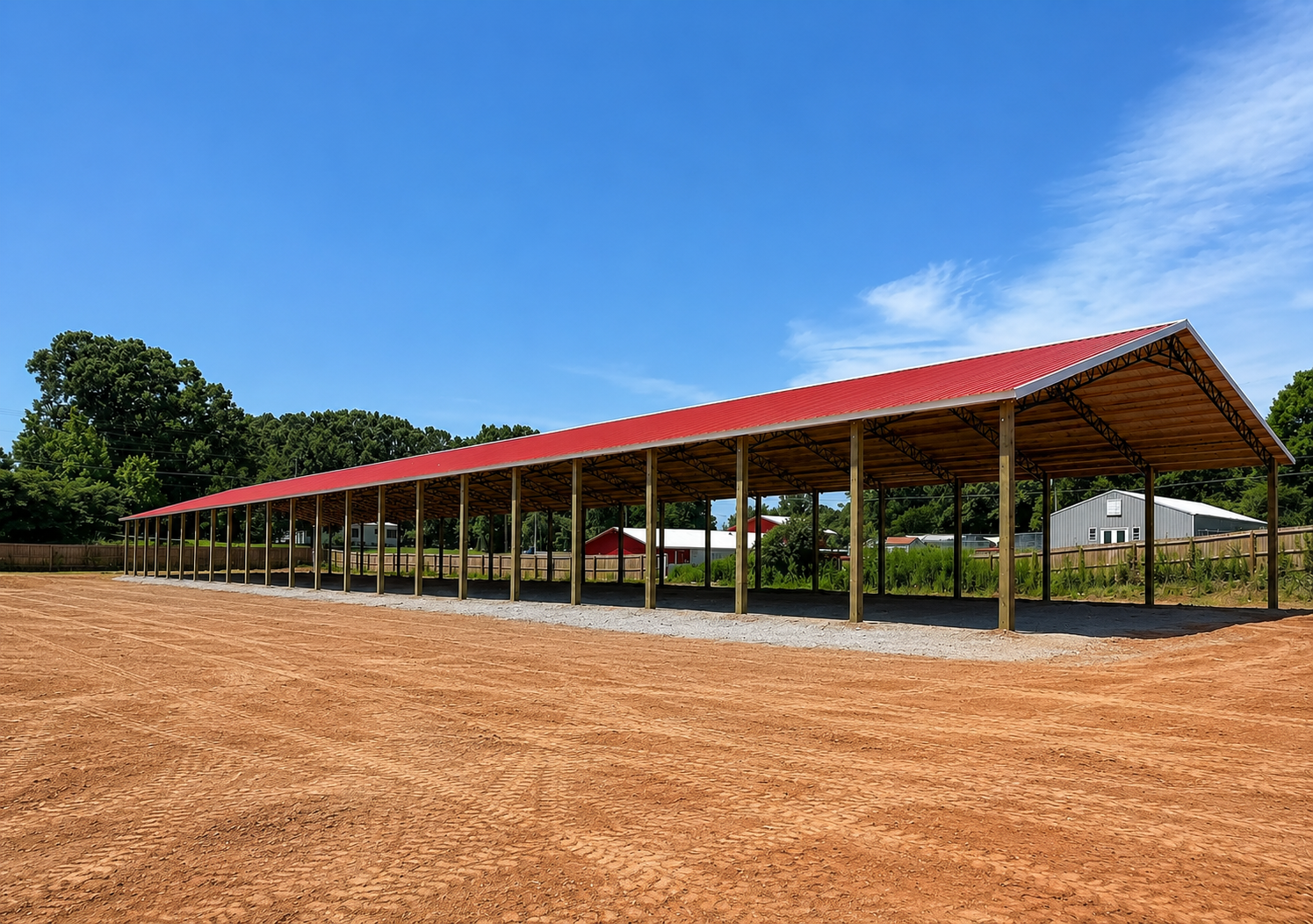 A wooden shelter with a metal roof in a grassy area, trees in the background, power lines overhead.