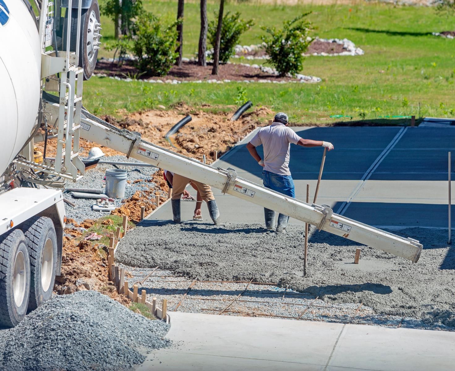 Concrete mixer truck pouring material into a prepared area.