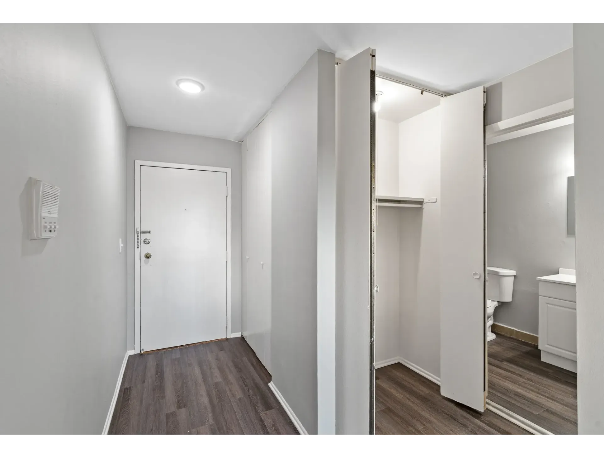 Interior view of an apartment entryway with closet and bathroom access
