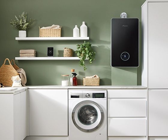 A modern laundry room with white cabinets, a washing machine, floating shelves, and a black wall-mounted water heater.