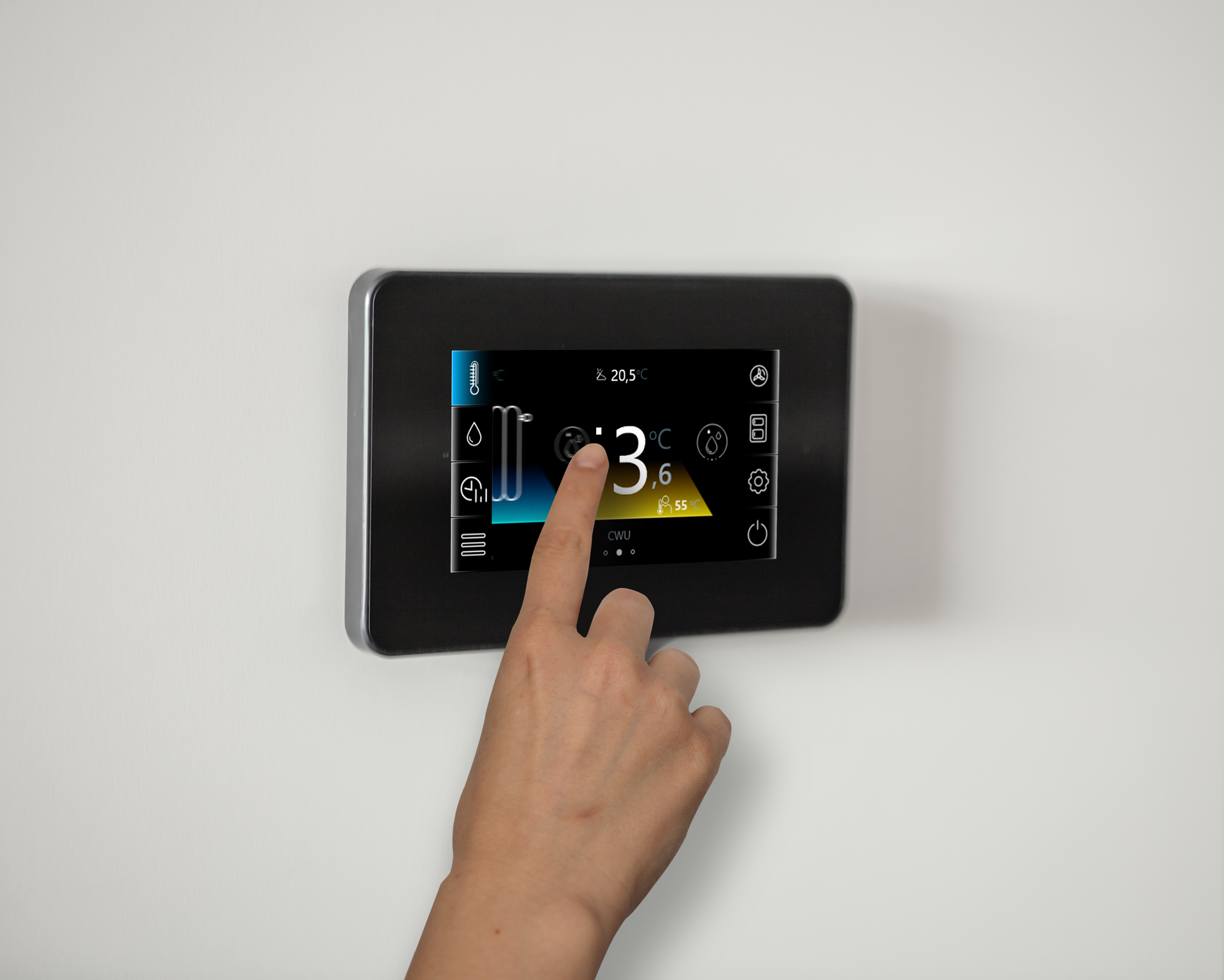 A finger touches a wall-mounted digital control panel displaying a temperature setting of 13 degrees against a white wall.