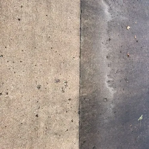 Side-by-side view of a light-colored concrete surface next to a darker, dirtier concrete surface, divided by a vertical line.