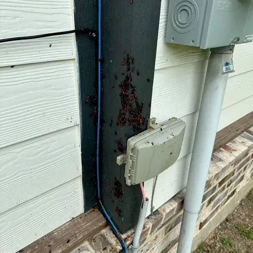 Exterior wall with siding, trim, and electrical boxes; reddish-brown stains visible.