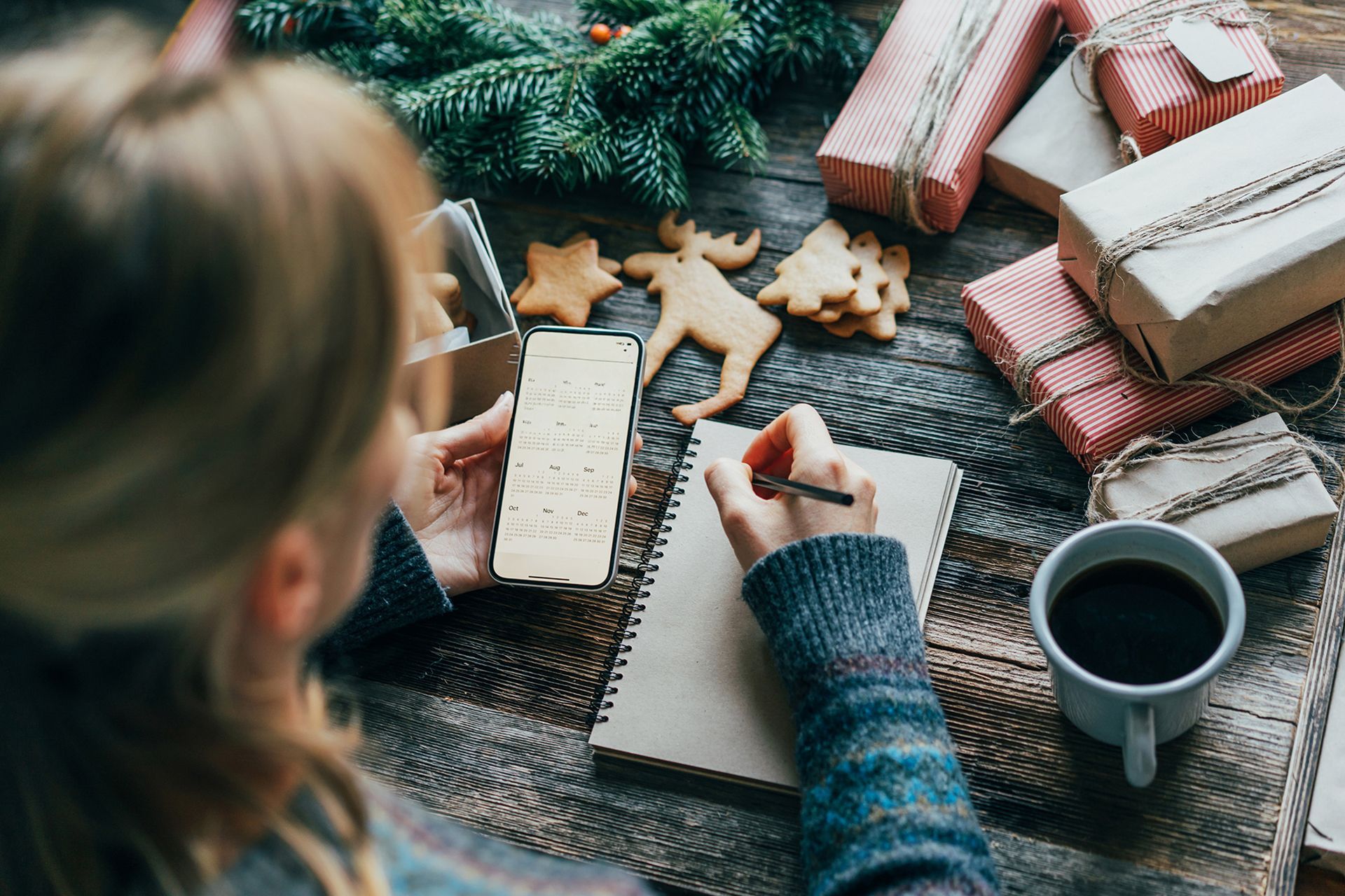 planning with a phone calendar and book, coffee and gifts