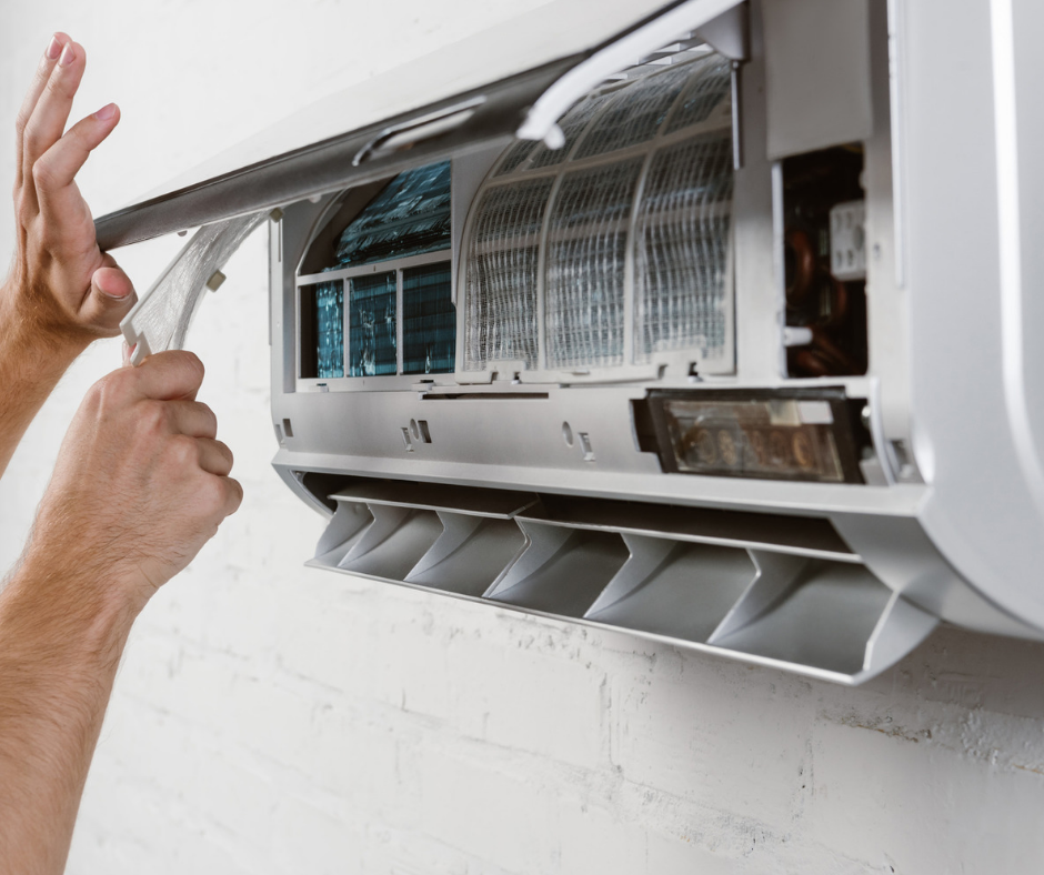 A person is cleaning a wall mounted air conditioner.