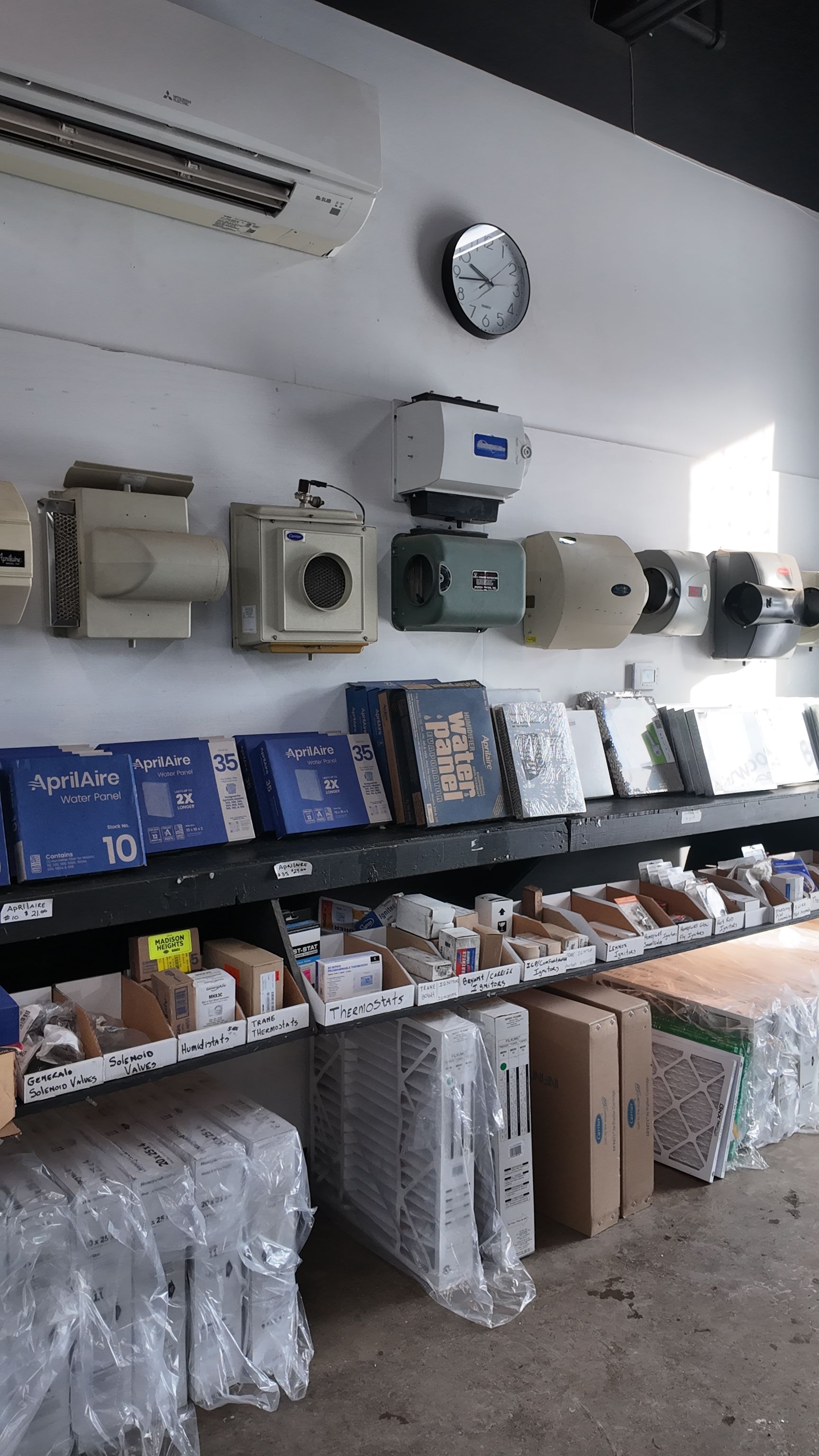 A shop interior with shelves displaying various electrical components and equipment mounted on the wall.
