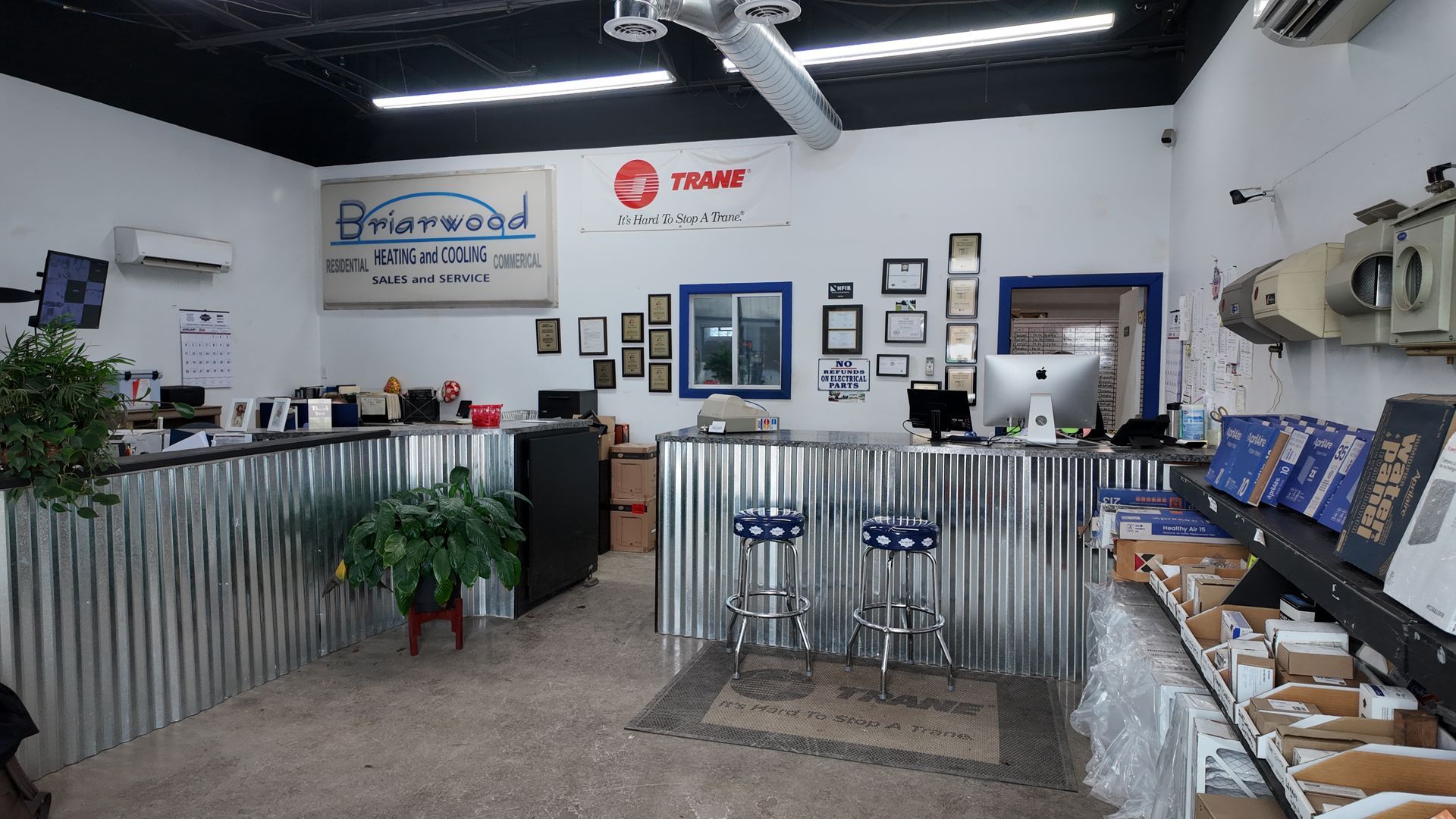 Office with corrugated metal counter, Frane sign, computer, and stools.