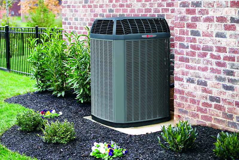 A large air conditioner is sitting on the side of a brick building. A large air conditioner is sitting on the side of a brick building.