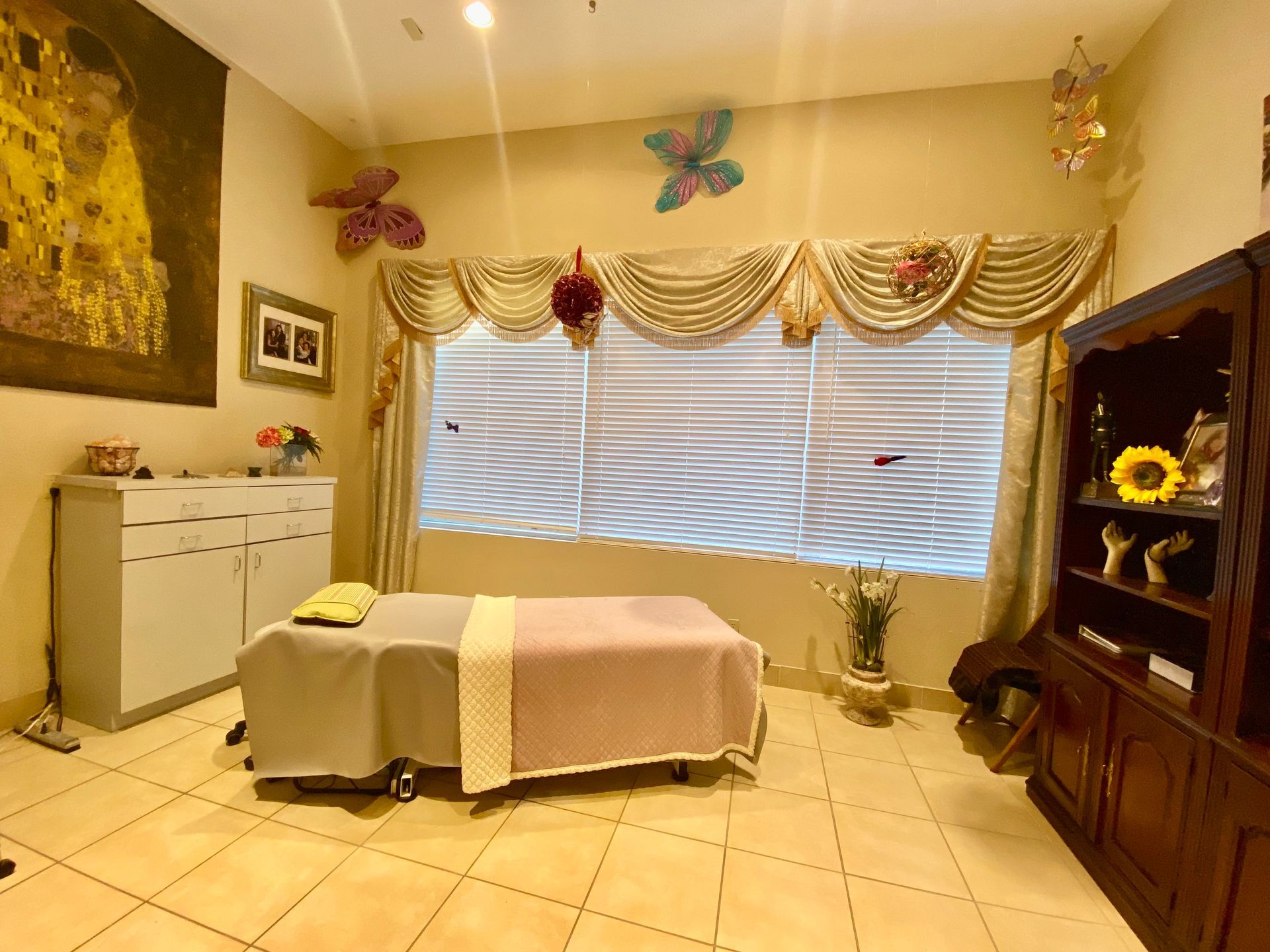 A room with a massage table and a window.