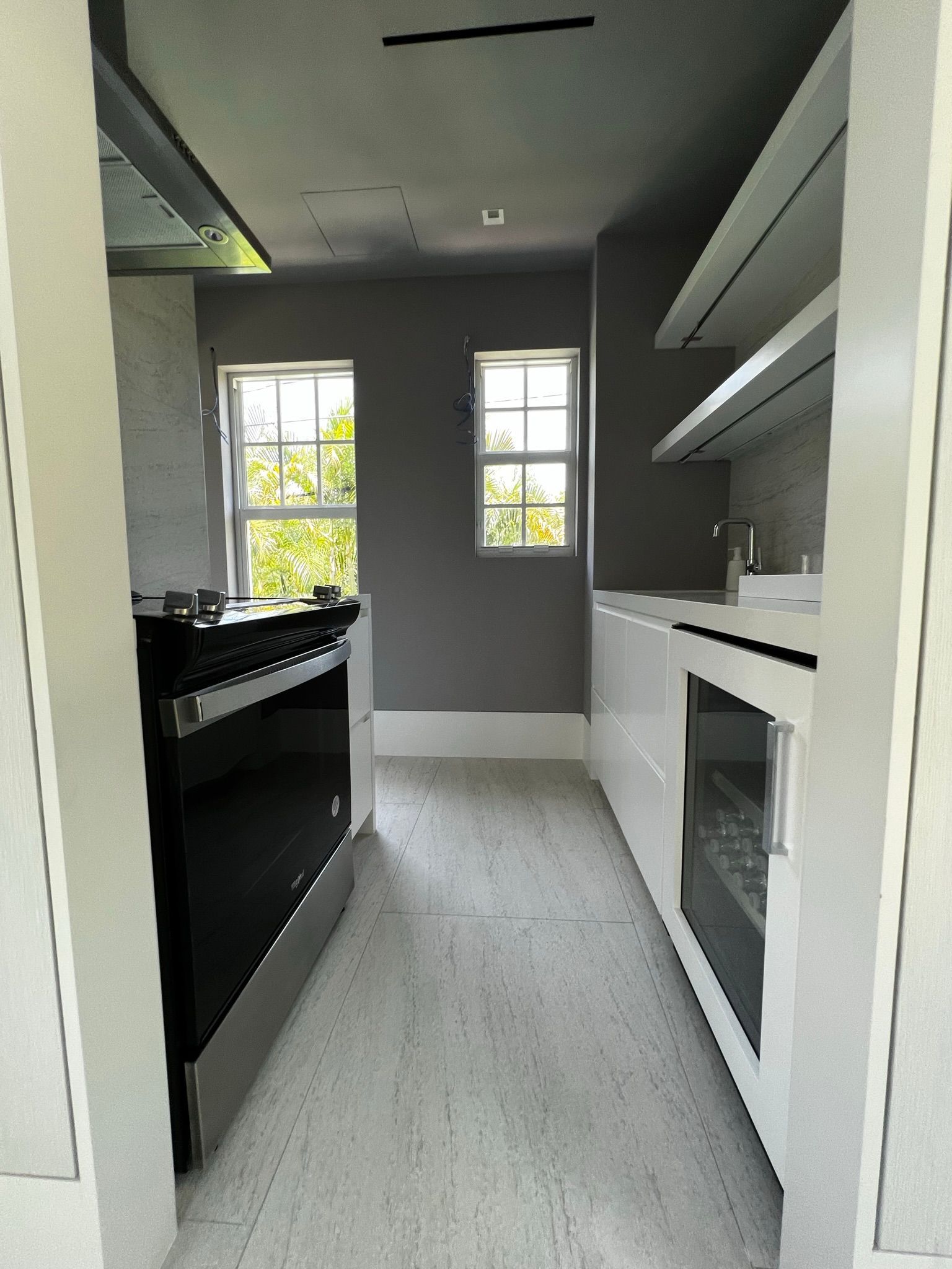 A kitchen with white cabinets and a black stove top oven