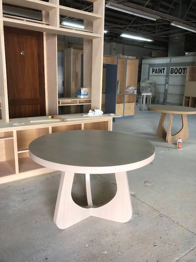 A round table is sitting in a room with a sign that says paint booth.