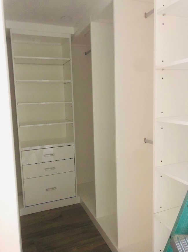 A walk in closet with lots of shelves and drawers.