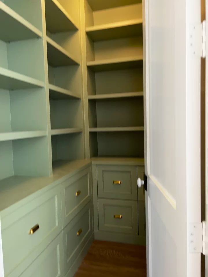 A walk in closet with lots of shelves and drawers