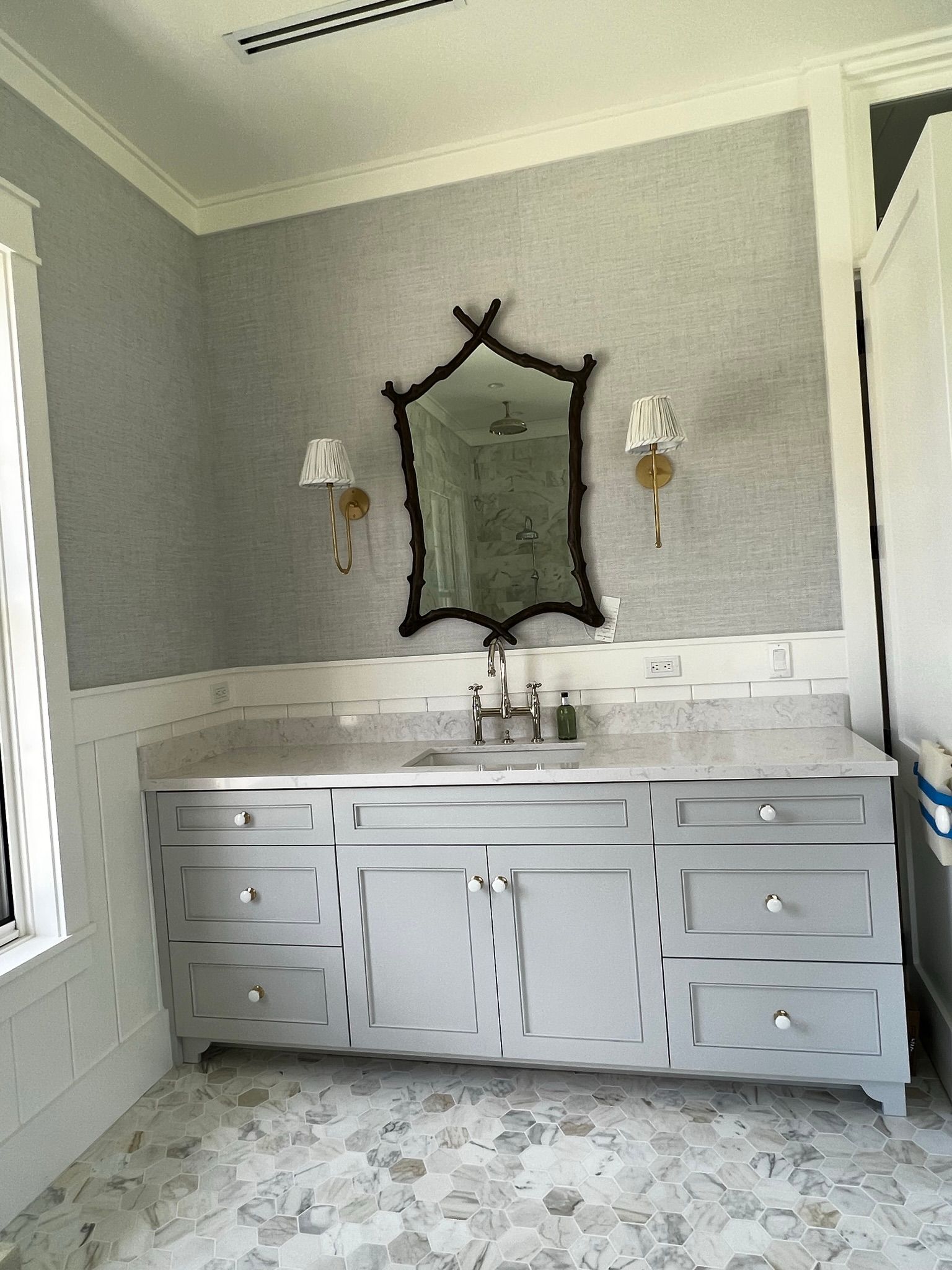 A bathroom with a sink , mirror and drawers.