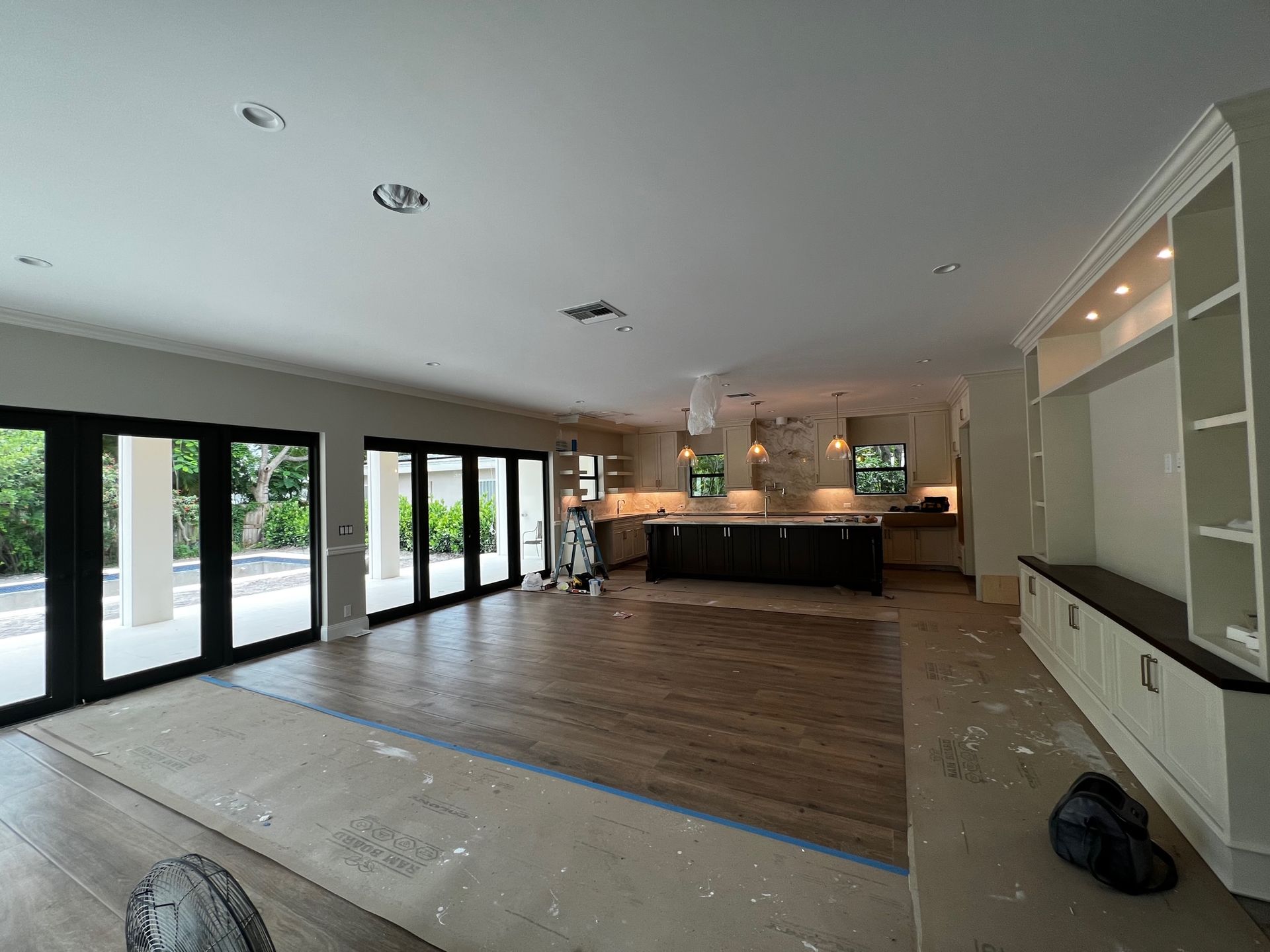 A large room with a lot of windows and a kitchen in the background.