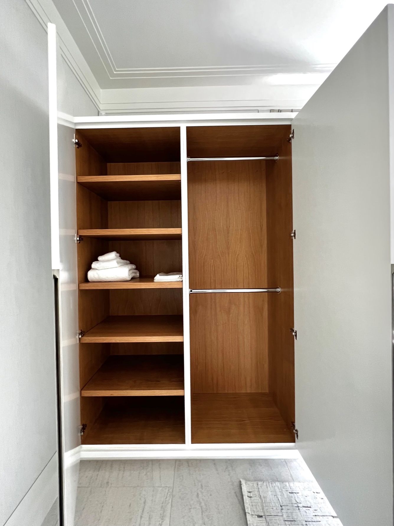 A closet with the doors open and shelves filled with towels