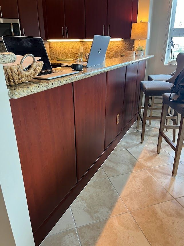 A laptop is sitting on a counter in a kitchen.